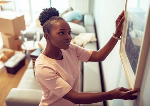 Wiley Insurance Services | Rock Hill, SC | young woman hanging a picture in her apartment